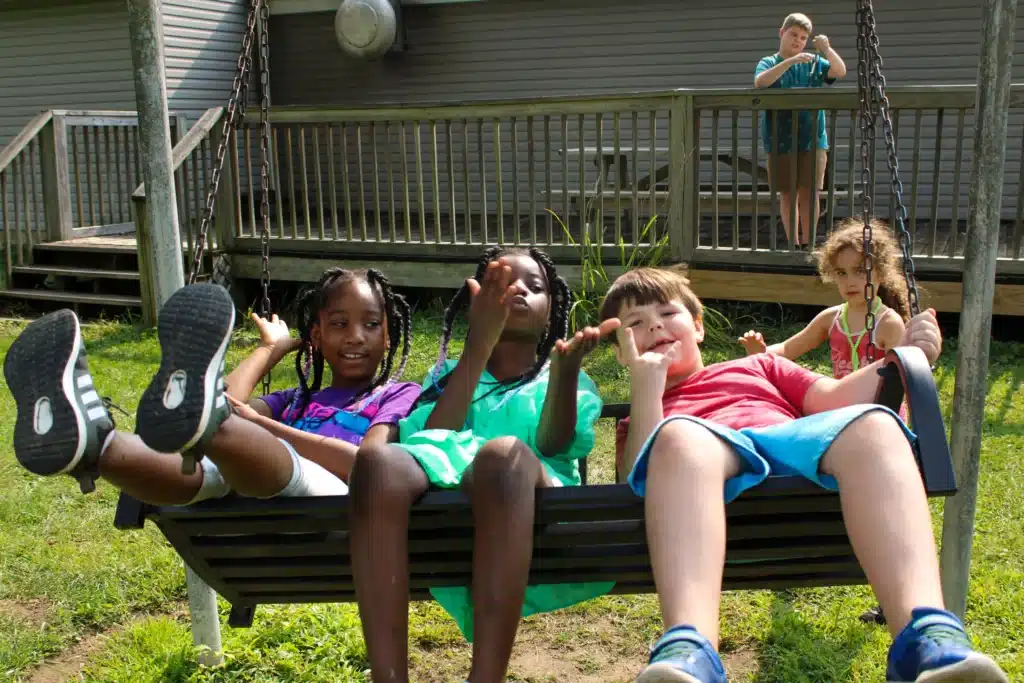 3 kids having fun Summer Camp Swing