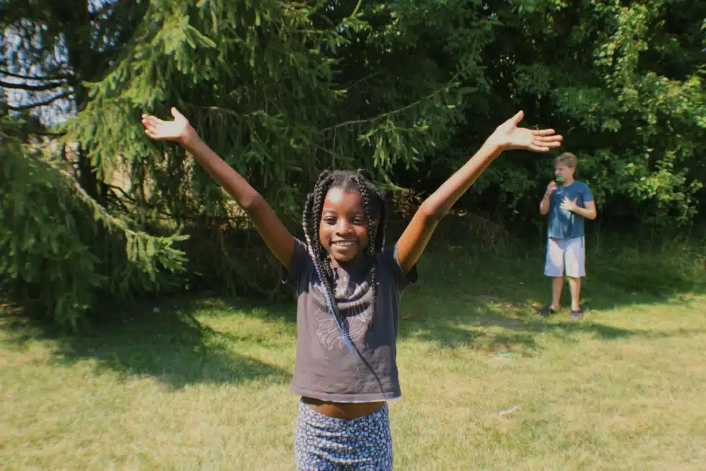 Girl raising her hands happy at summer camp